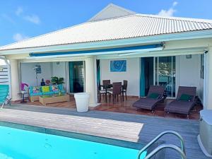 a house with a deck and a swimming pool at PERLE DES ANTILLES in Oyster Pond
