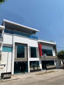 a large white building with windows on a street at Hotel Barrancabermeja Plaza in Barrancabermeja