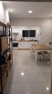 cocina con mesa y sillas en una habitación en Casa espaciosa en Ramallo cerca del Río en Ramallo