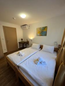 um quarto de hotel com duas camas com toalhas em Villa Klara em Novi Sad