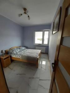 een slaapkamer met een bed en een raam bij APARTAMENT UNIEJÓW Długa in Uniejow