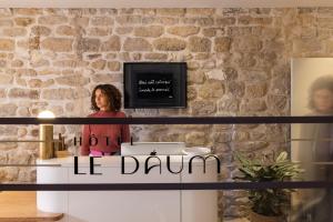 Une femme debout derrière une table avec les mots qu'il tambour dans l'établissement Hôtel Le Daum, à Paris