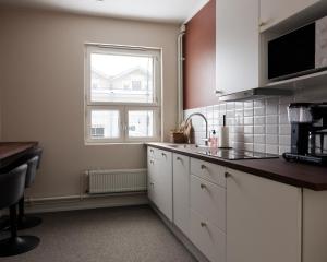 a kitchen with white cabinets and a window at Johanssonin talo 1849 in Joensuu