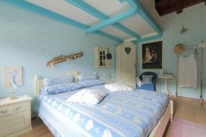 1 dormitorio con 1 cama grande y paredes azules en The Duck's Cottage, en Feltre