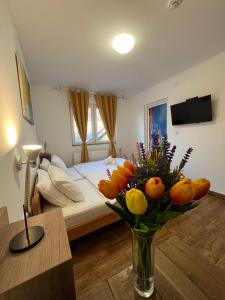 a bedroom with a bed and a vase of flowers at Villa Klara in Novi Sad