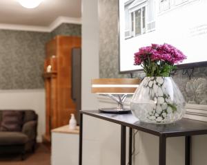a vase with flowers on a table in a living room at Johanssonin talo 1849 in Joensuu +84 photos