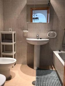 a bathroom with a sink and a toilet and a mirror at Lovely one bedroom unit with balcony and pool in Denia