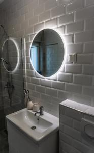 La salle de bains blanche est pourvue d'un lavabo et d'un miroir. dans l'établissement Babvirág Porta Fonyódliget, à Fonyód