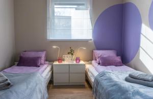 two beds in a room with purple pillows at Babvirág Porta Fonyódliget in Fonyód