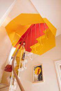 a yellow and red staircase in a house at Hôtel Le Daum in Paris