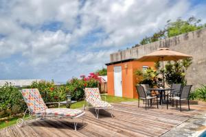 ビエケスにあるVieques Island House with Caribbean Views and Pool!のデッキ(テーブル、椅子、パラソル付)