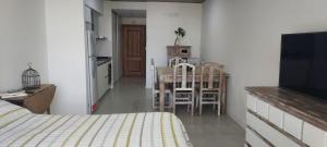 a bedroom with a bed and a kitchen with a table and chairs at Espacioso monoambiente en pleno centro in Adrogué