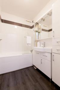 La salle de bains blanche est pourvue d'une baignoire et d'un lavabo. dans l'établissement LE KERNOGUET, à Vannes