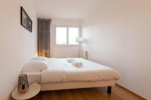 a bedroom with a bed with two stuffed animals on it at LE KERNOGUET in Vannes