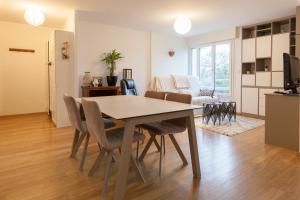 a dining room and living room with a table and chairs at LE KERNOGUET in Vannes +9 photos