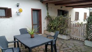 a table and chairs on a patio with a fence at 8380 Il Glicine in Albinia +11 photos