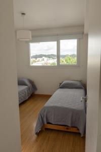 1 dormitorio con cama y ventana en Departamento en el centro ciudad con vista al calvario. en Tandil