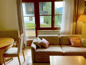 ein Wohnzimmer mit einem Sofa, einem Tisch und einem Fenster in der Unterkunft The Mountain Home in Hermagor
