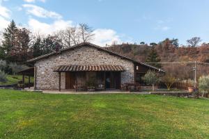 a large stone building with a grass yard at Agriturismo Ponte Di Riocchio in Gubbio