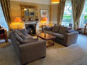 a living room with two couches and a fireplace at Glan Aber Hotel in Betws-y-coed