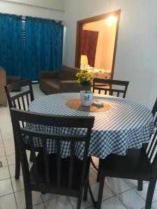 a dining room table with a blue and white checkered table cloth at Putri homestay Seaview pd in Port Dickson