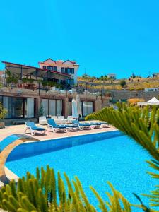a swimming pool with lounge chairs and a house at Selimiye Lime Garden in Selimiye