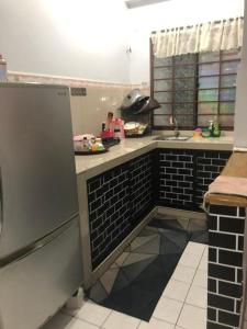 a kitchen with black and white tiles and a sink at Putri homestay Seaview pd in Port Dickson