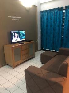 a living room with a tv and a couch at Putri homestay Seaview pd in Port Dickson