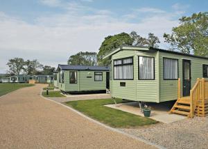 a row of green mobile homes in a park at York House Country Park in Thirsk