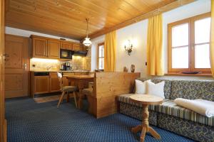 a living room with a couch and a table and a kitchen at Obersteinberg-Hof in Ruhpolding