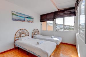 twee bedden in een kamer met twee ramen bij Las Brisas FREE WIFI in Adeje