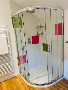 um chuveiro com azulejos coloridos na casa de banho em Meadow View em Mayfield