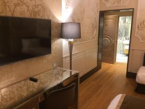 Pokój hotelowy z telewizorem z płaskim ekranem na ścianie w obiekcie Santa Croce Boutique Hotel w Wenecji