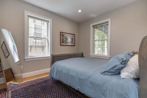 a bedroom with a bed and two windows at Sunny convenient home w/ private patio! Easy walk to everything! in Boston