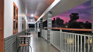 een balkon met een tafel en stoelen en een zonsondergang bij Tanto Hotel in Waingapu