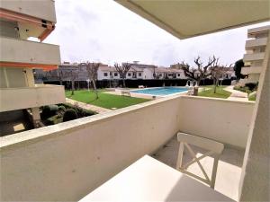 a white chair on a balcony with a view of a pool at Villa Service - Prat de Calafell in Calafell