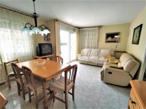 a living room with a table and a couch at Villa Service - Prat de Calafell in Calafell