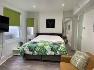a bedroom with a bed and a couch and a television at Mildmay Road Apartments in London