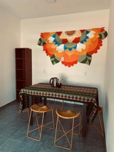 a table with two chairs and a painting on the wall at Hostel Casa Blanca in San Luis