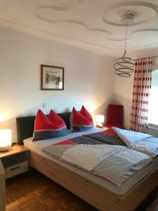 a bedroom with a bed with red pillows on it at Apartment Kirchenblick in Weissenkirchen in der Wachau