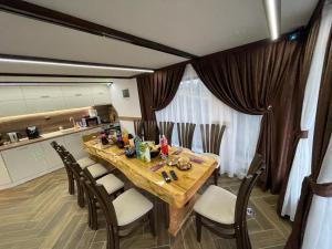 - une salle à manger avec une table et des chaises en bois dans l'établissement Villa ART, à Dospat