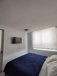 a bedroom with a blue bed and a window at Sector Av. Brasil 1D1B - 4P edificio in Antofagasta
