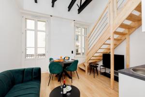 ein Wohnzimmer mit einem grünen Sofa und einem Tisch in der Unterkunft Palmalodge YourHostHelper in Cannes