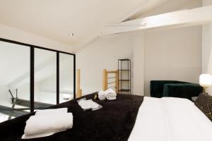 ein Schlafzimmer mit einem großen Bett mit Handtüchern darauf in der Unterkunft Palmalodge YourHostHelper in Cannes