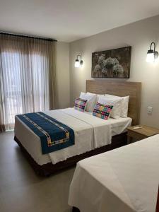 ein Schlafzimmer mit einem großen Bett mit zwei Kissen in der Unterkunft Resort Quinta Santa Barbara 18 a 24 Agosto in Pirenópolis