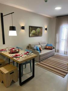 ein Wohnzimmer mit einem Tisch und einem Sofa in der Unterkunft Resort Quinta Santa Barbara 18 a 24 Agosto in Pirenópolis