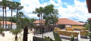 a courtyard with palm trees and yellow chairs at Resort Quinta Santa Barbara 30 dez 2025 a 06 jan 2026 in Pirenópolis