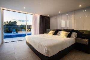 a bedroom with a large bed and a large window at Golf Palms in Costa Teguise +43 photos