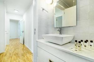 a white bathroom with a sink and a mirror at Matosinhos Wonderfull apartment by Innkeeper in Matosinhos