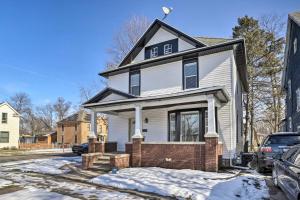 a white house with a black roof in the snow at Pet-Friendly Home Rental Near Notre Dame! in South Bend